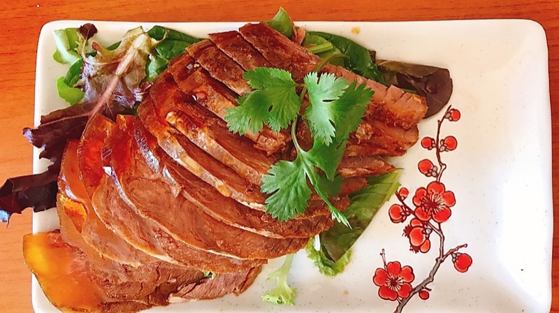 Sliced braised beef with cilantro garnish