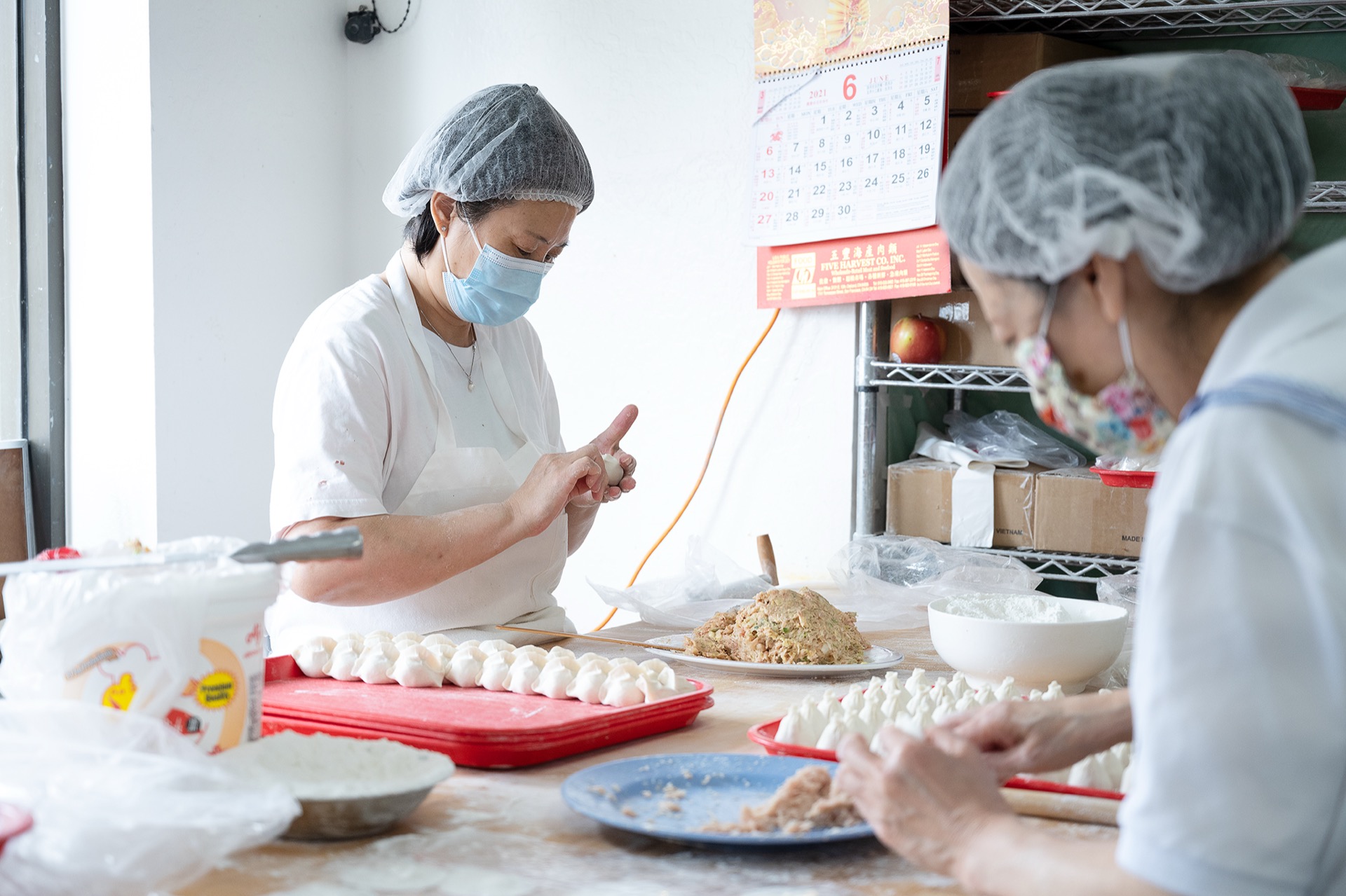 兩位員工在工作臺前一起包餃子