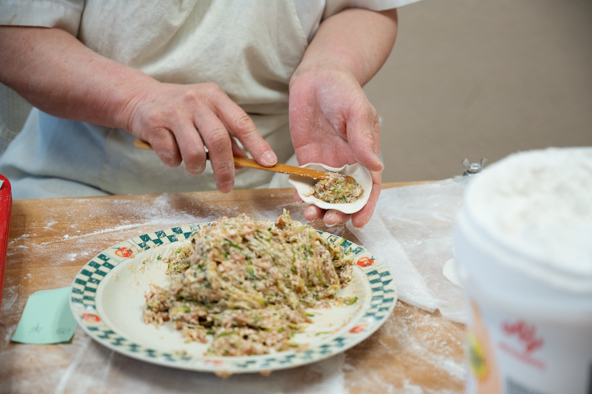 特寫用筷子將餡料放入餃子皮