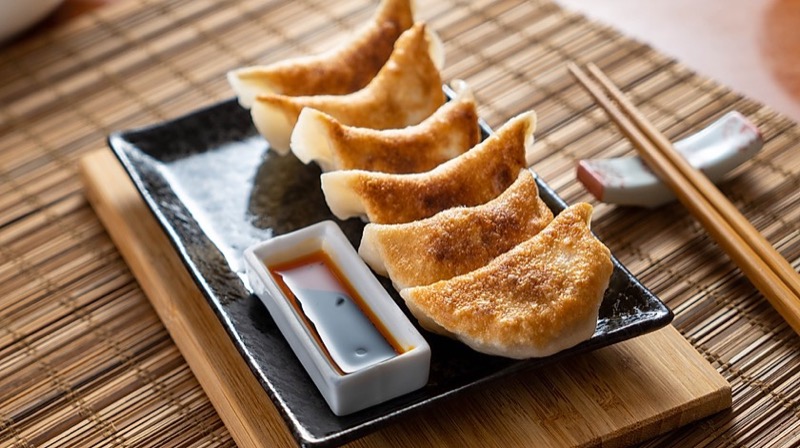 Golden pan-fried potstickers with dipping sauce